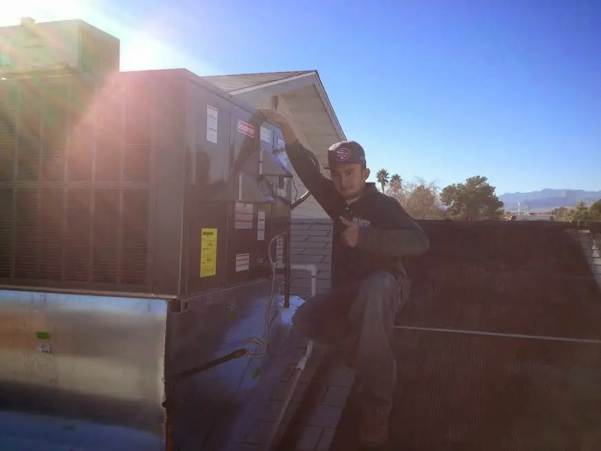 HVAC technician performing HVAC Inspection on a rooftop unit in Kayenta